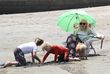Extrem eingehüllt verbringt sie einen Tag am Strand