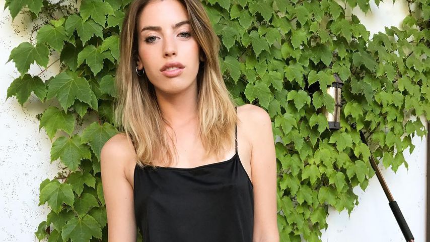 Model Clara McGregor posiert vor einer Efeuwand